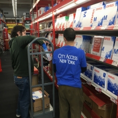 Participants work together to restock printing paper aisle at Staples.
