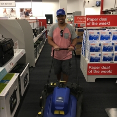 Participant vacuums an aisle while working at Staples.