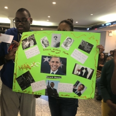 Participants holding up artwork celebrating Black History Month