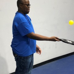 Participant bounces the ball with his paddle to improve his hand-eye coordination.