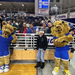 A participant is front and center with the Hofstra mascots as the rest of the group cheers her on.