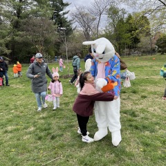 A little kid hugs the bunny.